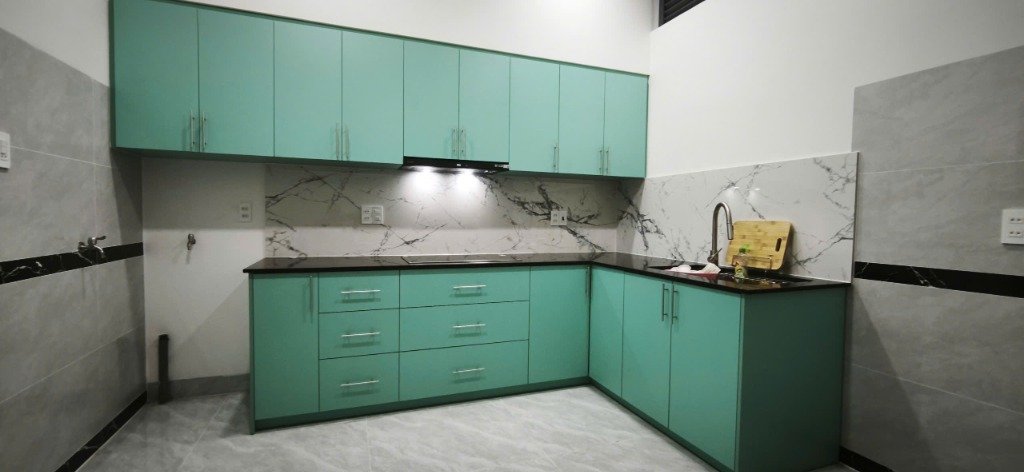 Bộ tủ bếp màu xanh ngọc nổi bật ở tầng trệt